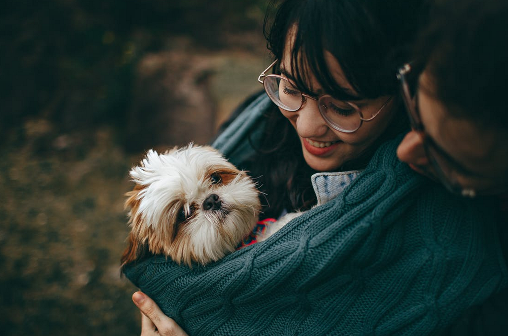 a woman carrying a dog